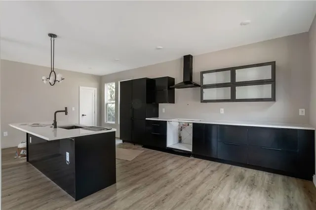 a kitchen with stainless steel appliances kitchen island a sink dishwasher a refrigerator and a stove with wooden floor