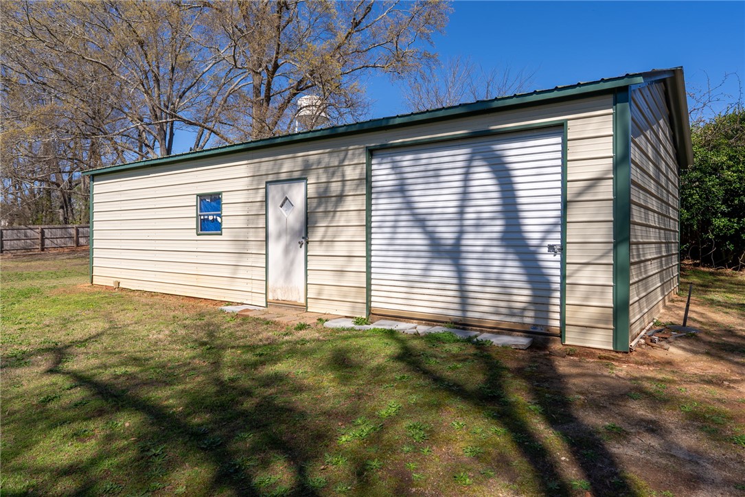 300 Green Street Williamston, SC 29697 - Photo 28 of 47 This metal outbuilding offers versatile space for storage or a workshop, blending practicality with rustic charm.