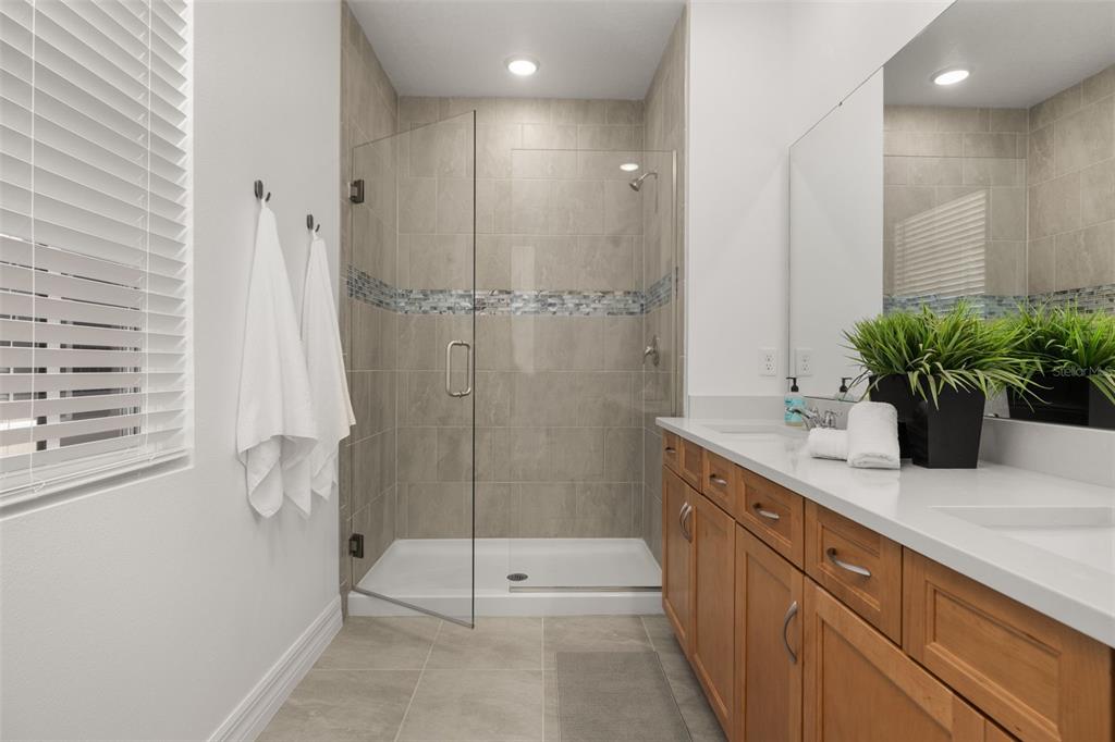 1849 Island Village Way Celebration, FL 34747 - Photo 30 of 50 a bathroom with a shower sink and mirror