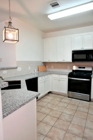 a kitchen with stainless steel appliances granite countertop a sink and a stove