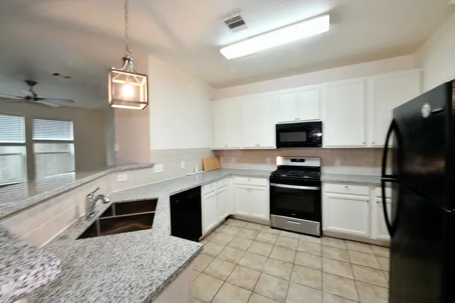 a kitchen with stainless steel appliances granite countertop a sink dishwasher stove top oven and refrigerator