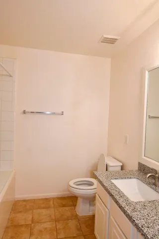 an empty room with a window and chandelier fan