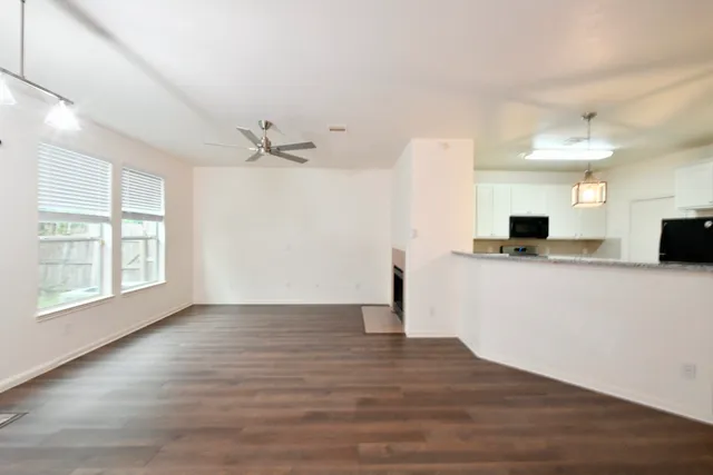 a view of a kitchen with wooden floor and a ceiling fan