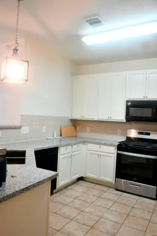 a kitchen with granite countertop a sink and a stove