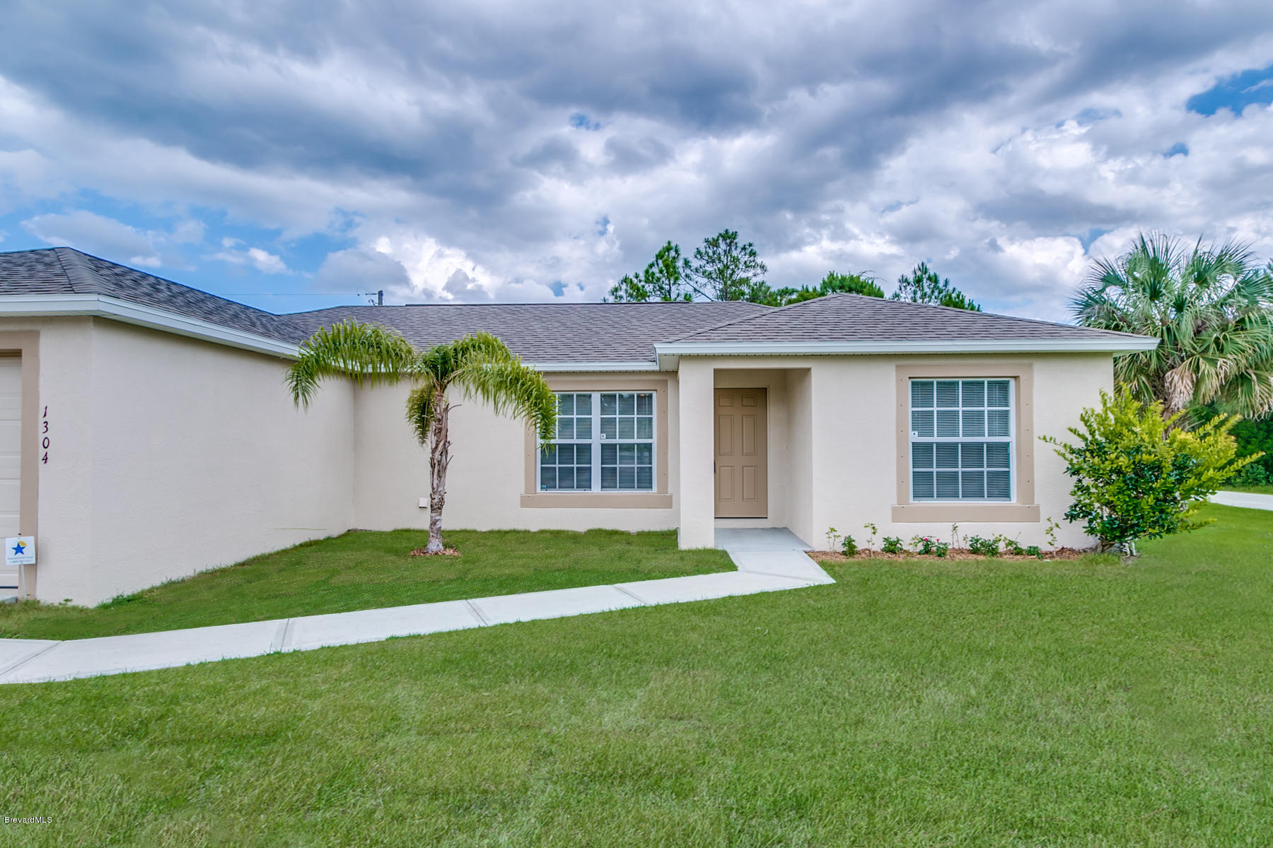 1304 Rabbit Street Southeast Palm Bay, FL 32909 - Photo 7 of 37 a front view of a house with a garden and yard