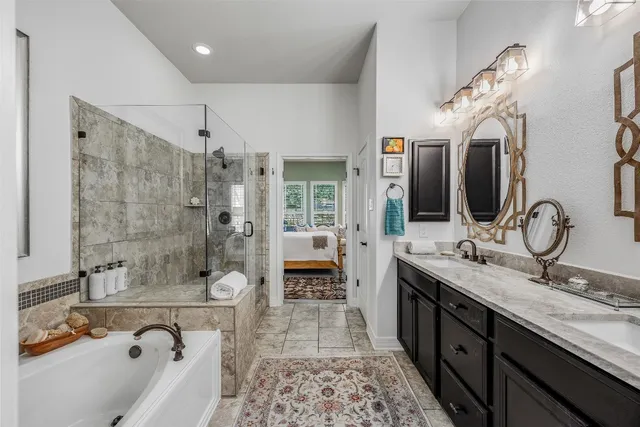 a spacious bathroom with a granite countertop sink mirror and shower