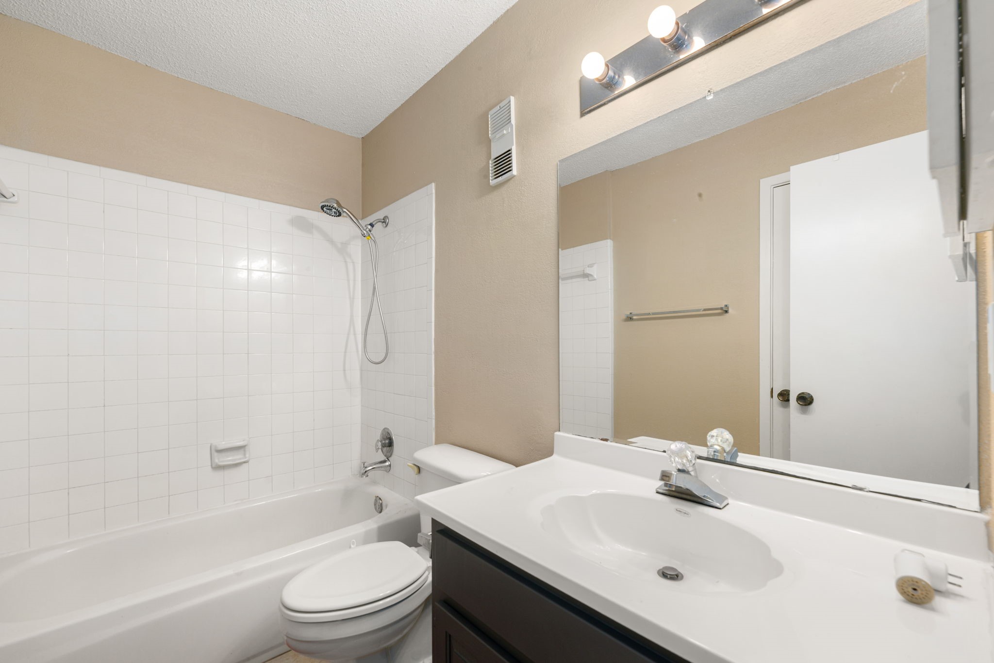 3200 South Gessner Road, Unit 228 Houston, TX 77063 - Photo 13 of 18 The secondary full bath offers a dark vanity with a quartz countertop, a large mirror, tiled tub/shower combo, and tile flooring, a functional and well-appointed space for family or guests!