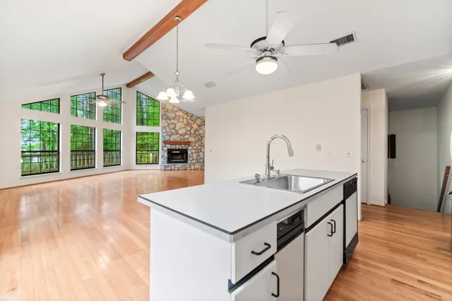 a kitchen with kitchen island a large counter top space a sink stainless steel appliances and cabinets