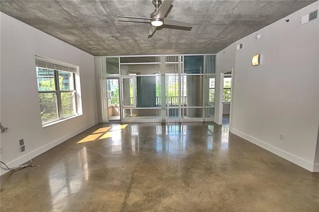 an empty room with floor to ceiling windows and chandelier