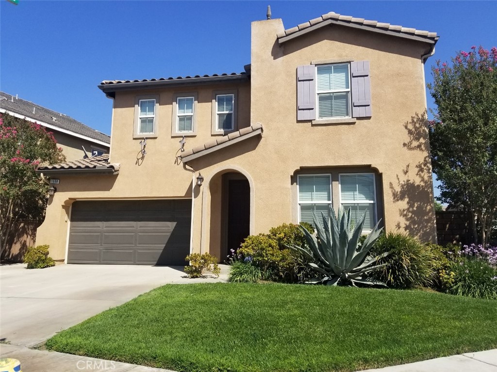 1688 Julia Way Riverside, CA 92501 - Photo 1 of 36 a front view of a house with a yard and garage