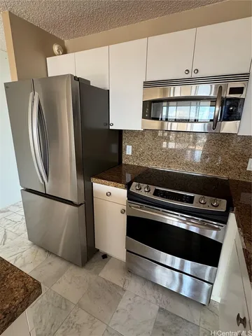 a kitchen with stainless steel appliances granite countertop a stove a refrigerator and a cabinets