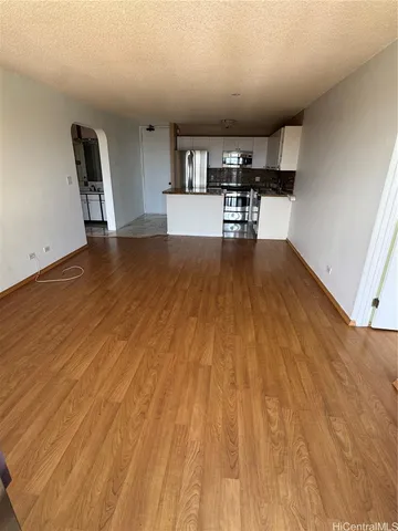 a view of a kitchen with kitchen island wooden floors and a fireplace