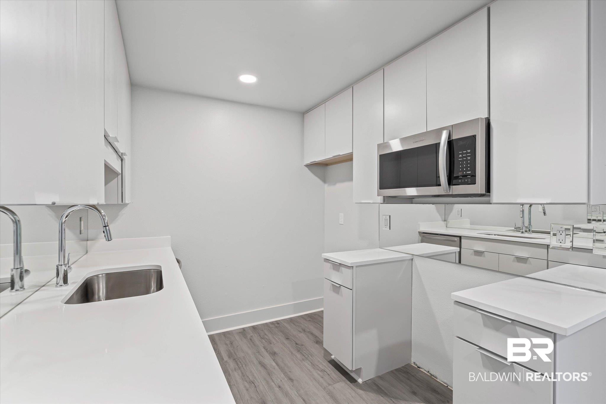 3655 Old Shell Road, Unit 712 Mobile, AL 36608 - Photo 7 of 19 Kitchen featuring light wood-style flooring, stainless steel microwave, white cabinets, modern cabinets, and recessed lighting