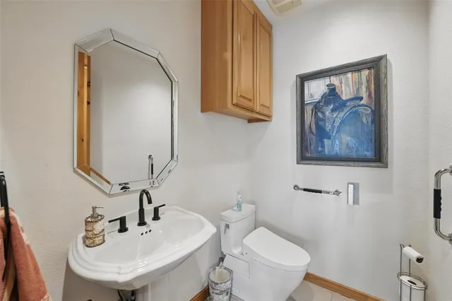 a bathroom with a toilet a sink and mirror
