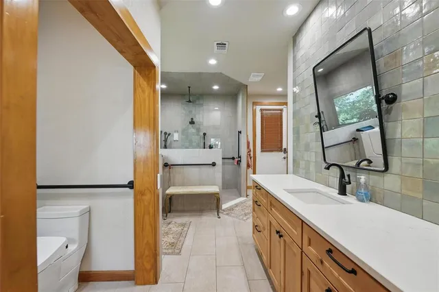 a spacious bathroom with a sink a toilet and a mirror