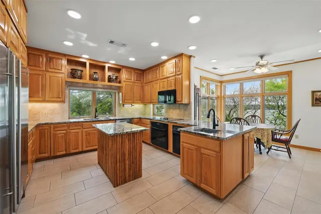 a kitchen with stainless steel appliances granite countertop a stove a sink dishwasher and a refrigerator