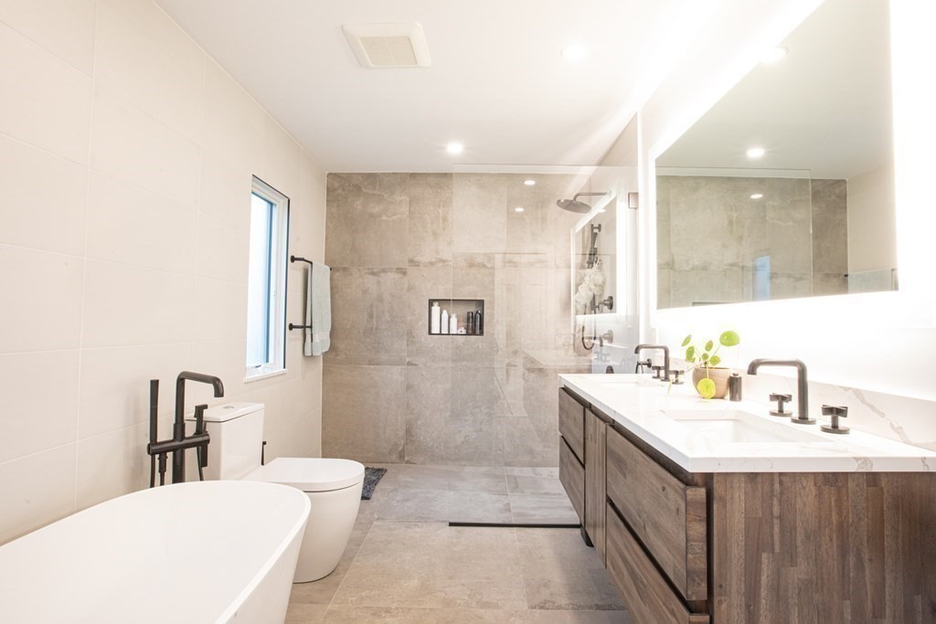 48 Amherst Road Belmont, MA 02478 - Photo 11 of 26 a bathroom with a double vanity sink a toilet a mirror and shower