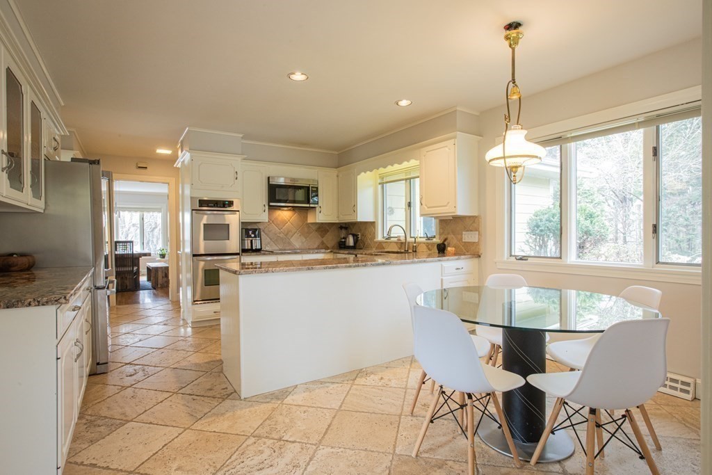 48 Amherst Road Belmont, MA 02478 - Photo 8 of 26 a kitchen with stainless steel appliances granite countertop a stove top oven a sink a dining table and chairs