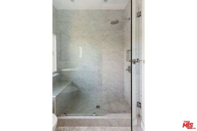 a white bath tub sitting next to a shower