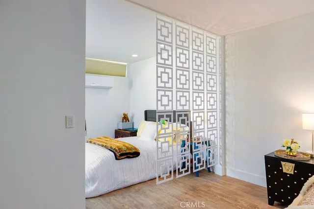 a bedroom with a bed and wooden floor