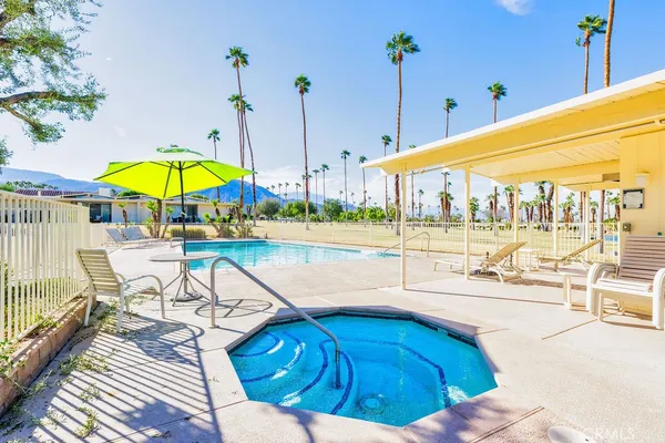 a view of a swimming pool with a chair and tables in the patio