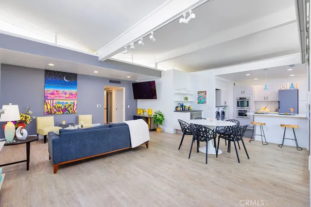 a living room with furniture a dining table and a wooden floor