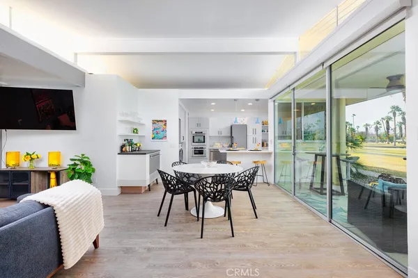 a living room with furniture a flat screen tv and a floor to ceiling window
