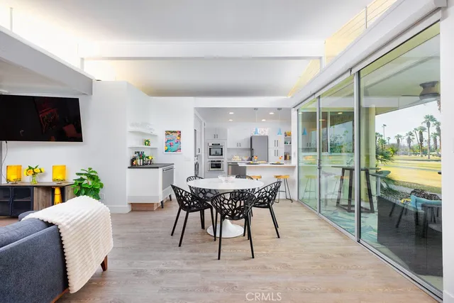 a living room with furniture a flat screen tv and a floor to ceiling window
