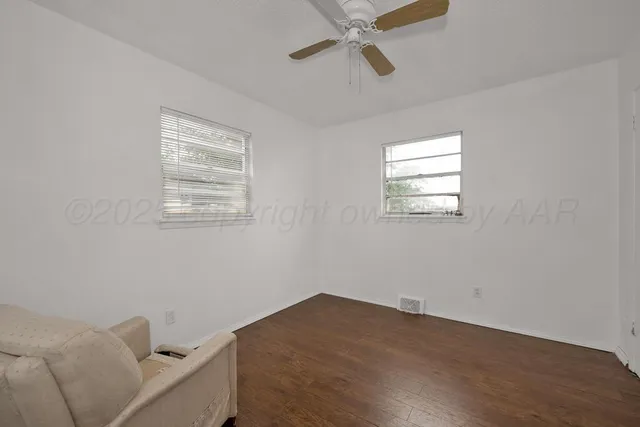a view of a room with wooden floor and windows