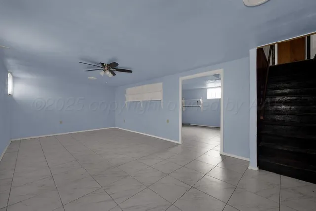 an empty room with fan and windows