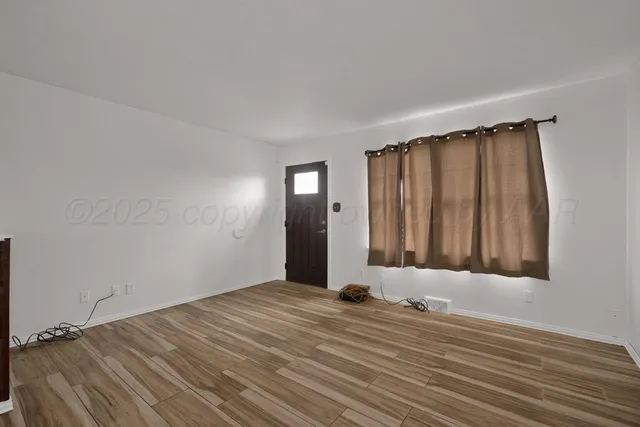 a view of a room with wooden floor and bench