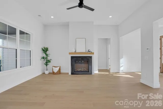 an empty room with fireplace and windows