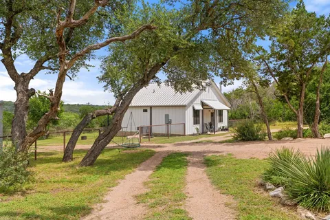 a front view of a house with a yard and trees
