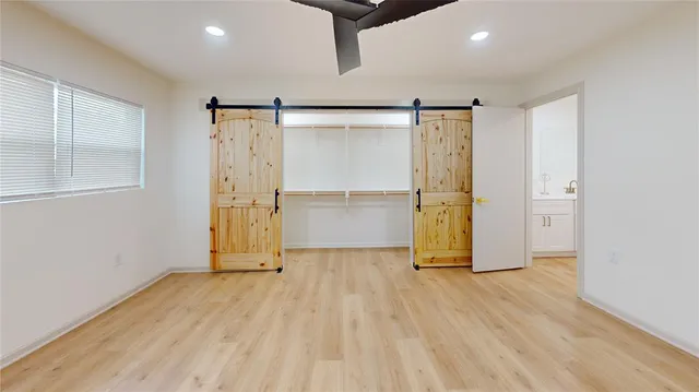 a view of empty room with wooden floor and windows