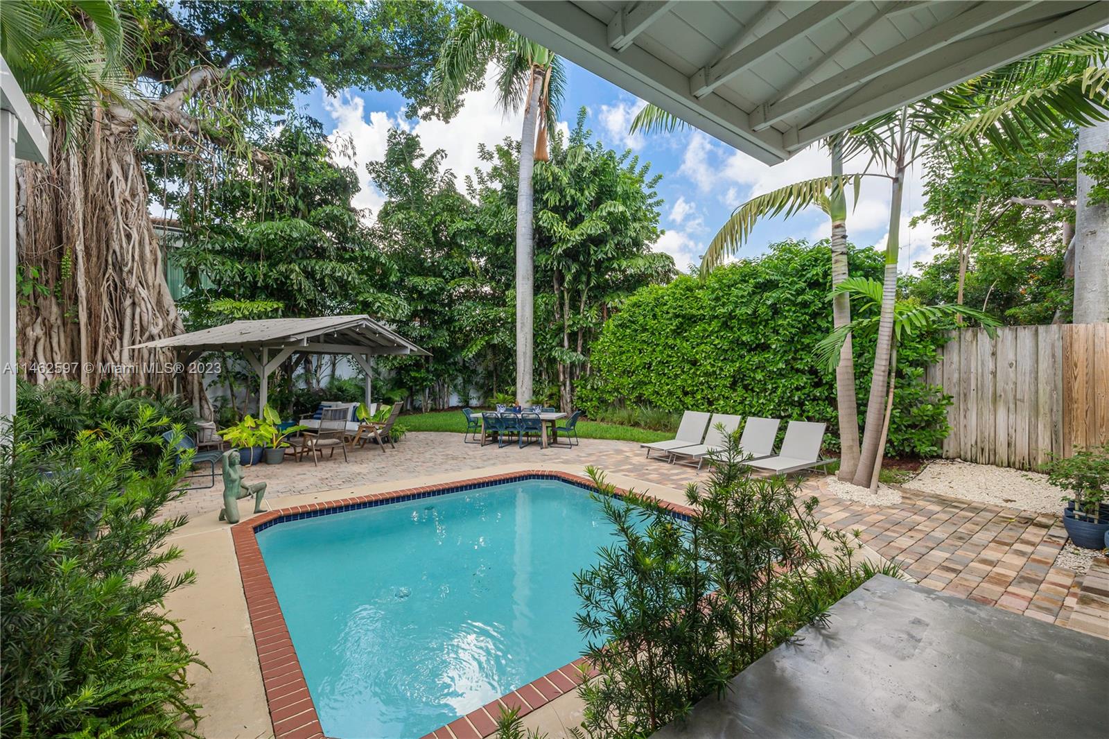 32 Southwest 23rd Road Miami, FL 33129 - Photo 25 of 34 a view of a patio with table and chairs under an umbrella with a small yard