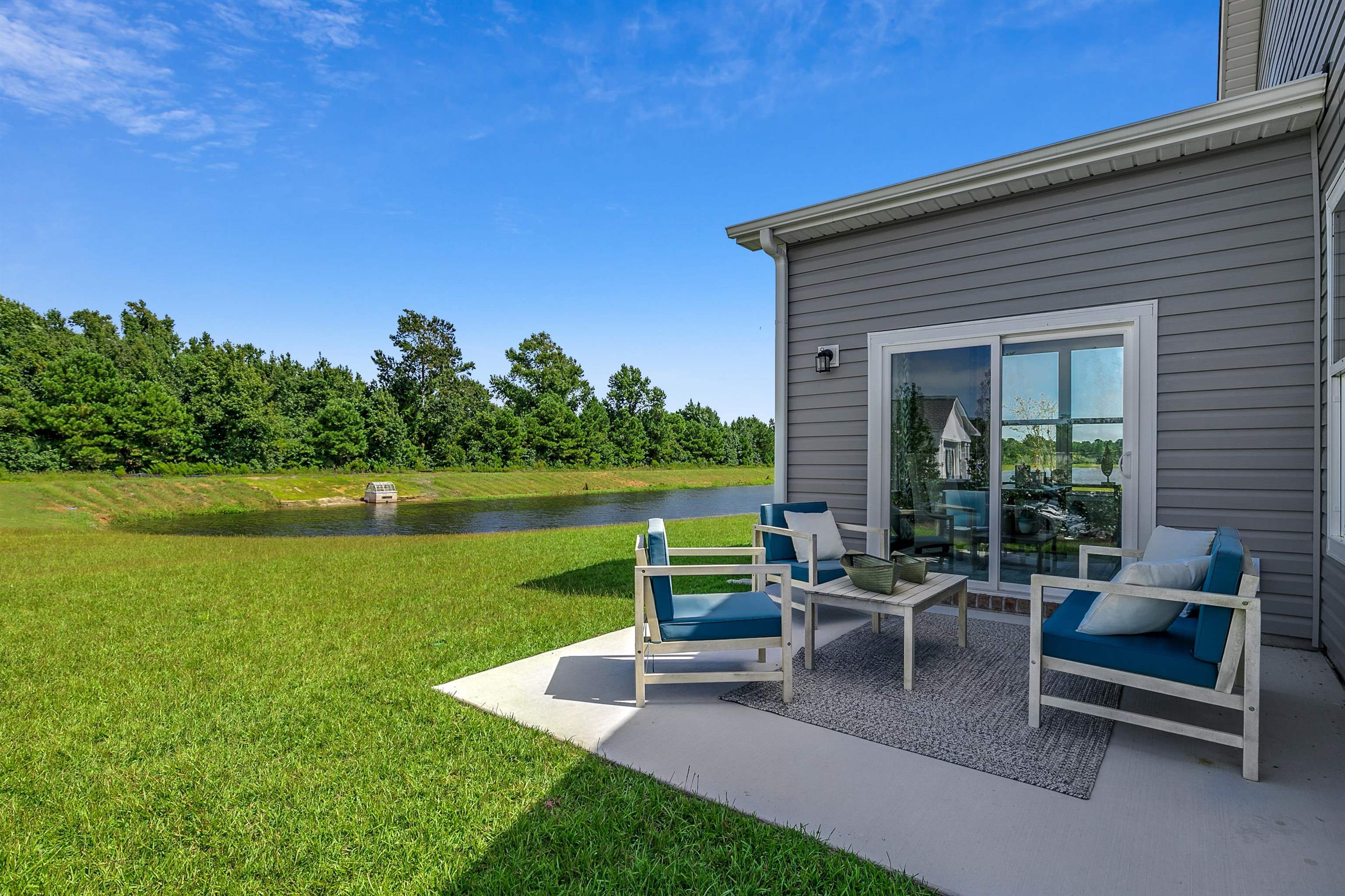 580 Kapalua Loop Little River, SC 29566 - Photo 15 of 24 View of green lawn featuring a patio, a water view, and an outdoor hangout area