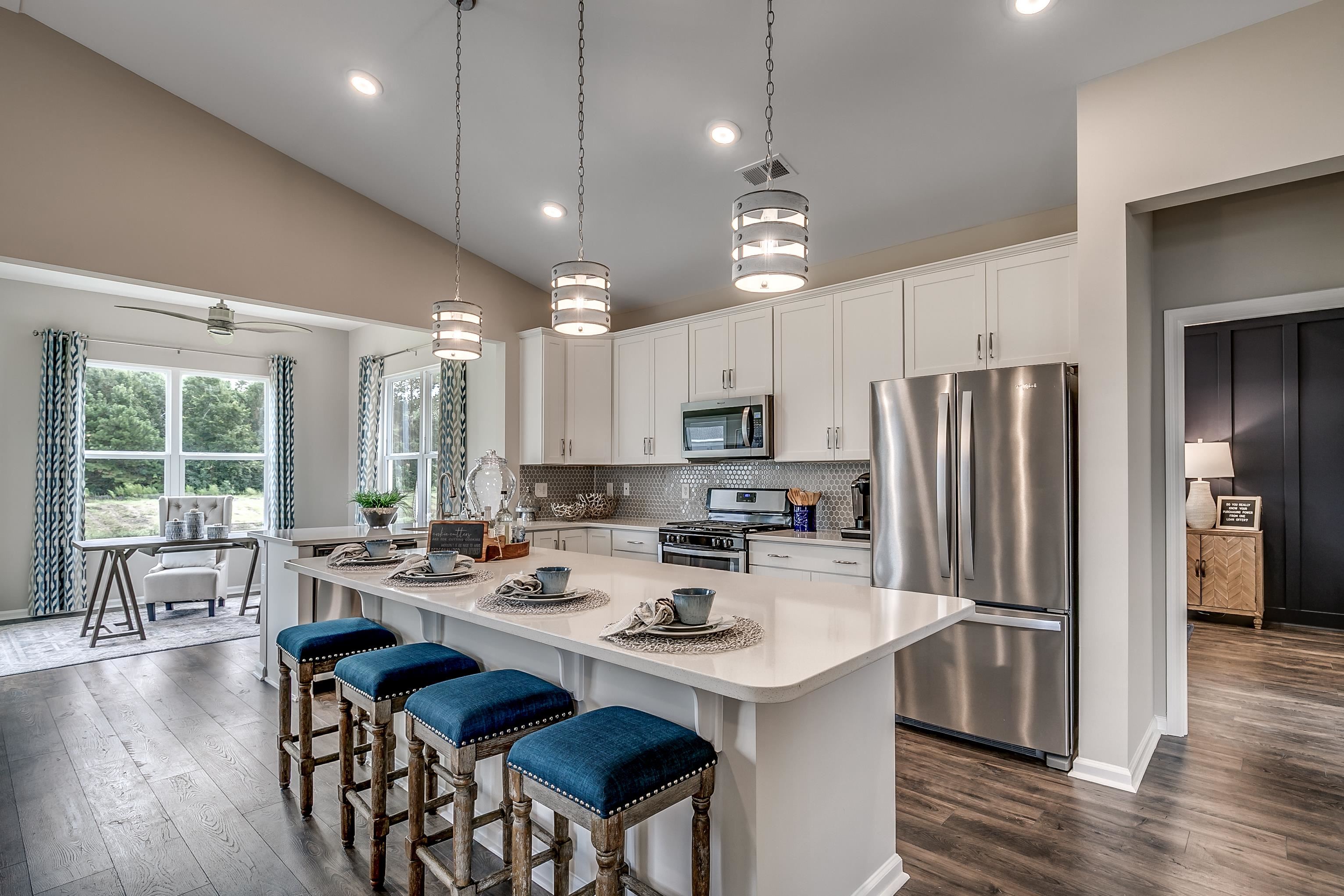 580 Kapalua Loop Little River, SC 29566 - Photo 7 of 24 Kitchen featuring a kitchen breakfast bar, stainless steel appliances, dark wood-style flooring, hanging light fixtures, and vaulted ceiling