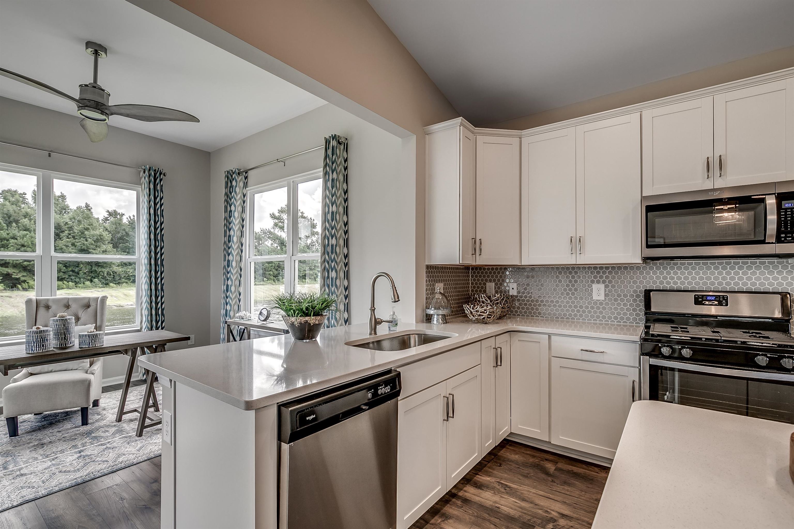 580 Kapalua Loop Little River, SC 29566 - Photo 8 of 24 Kitchen featuring white cabinets, stainless steel appliances, tasteful backsplash, and dark wood-style floors