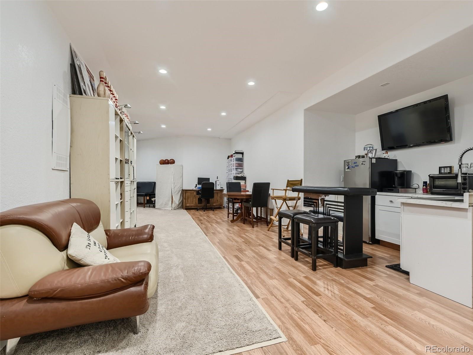 992 West Ridge Road Littleton, CO 80120 - Photo 33 of 44 a living room with furniture and a flat screen tv