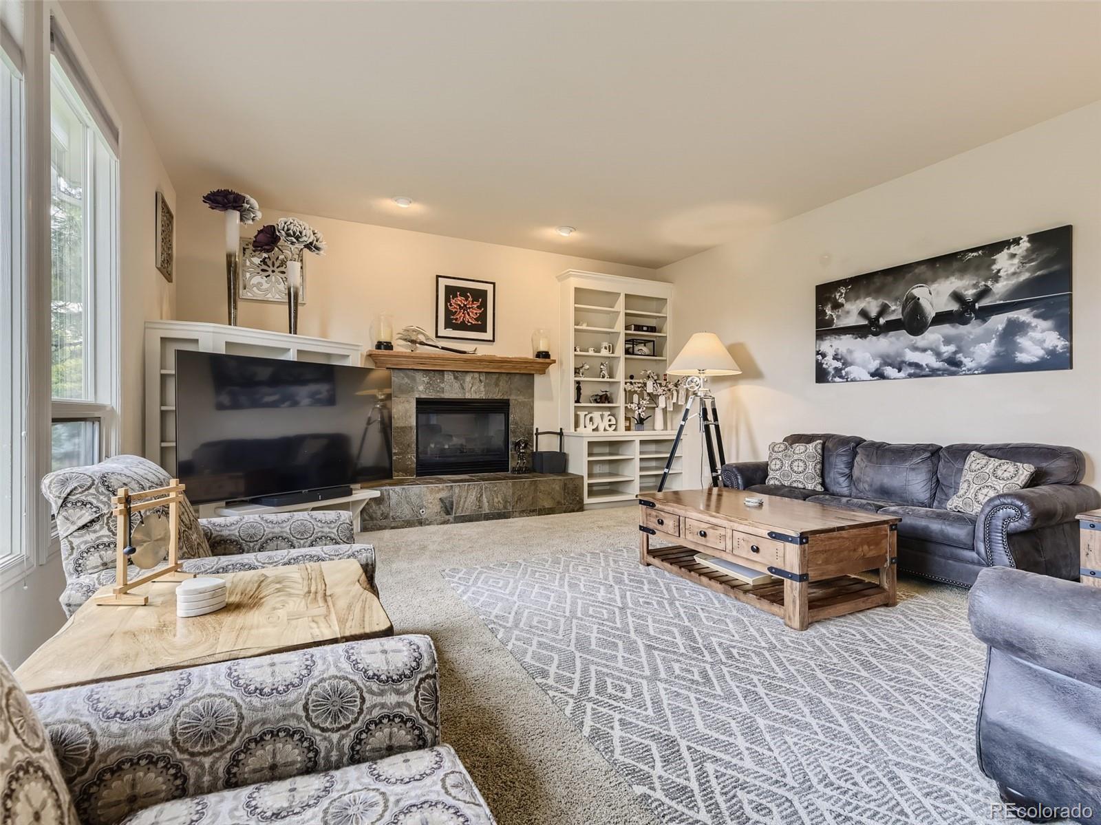 992 West Ridge Road Littleton, CO 80120 - Photo 6 of 44 a living room with furniture a fireplace and a flat screen tv
