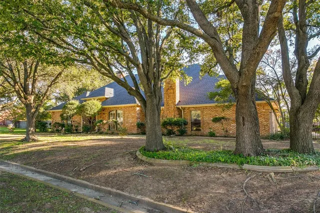 a front view of a house with a yard and an trees