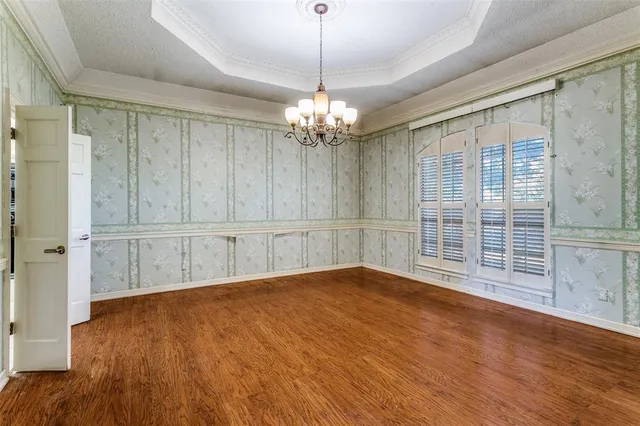 a view of wooden floor and a chandelier in a room