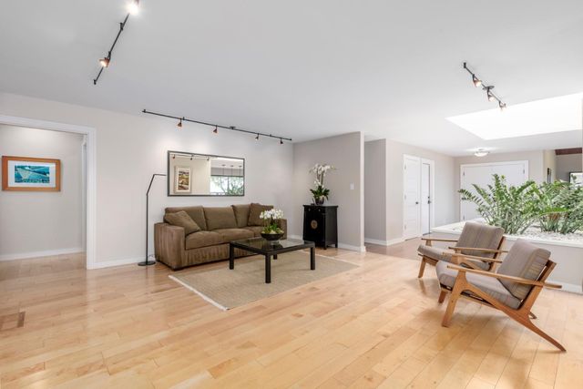 a dining room with furniture potted plants and wooden floor