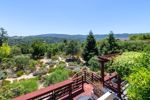 a view of a chairs and table on the wooden roof deck