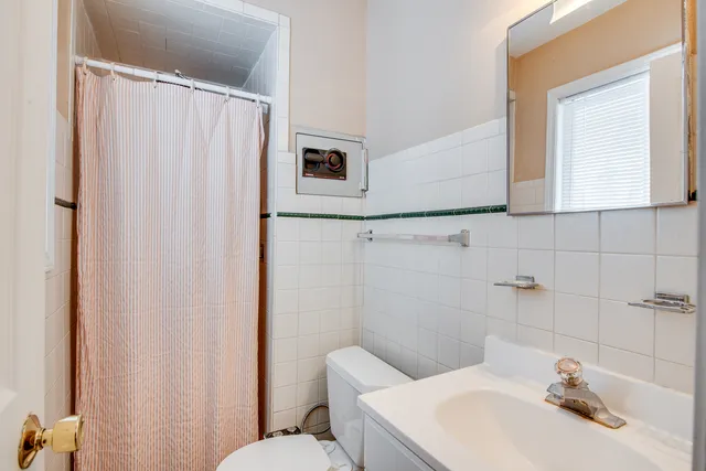 a bathroom with a sink a toilet and shower curtain