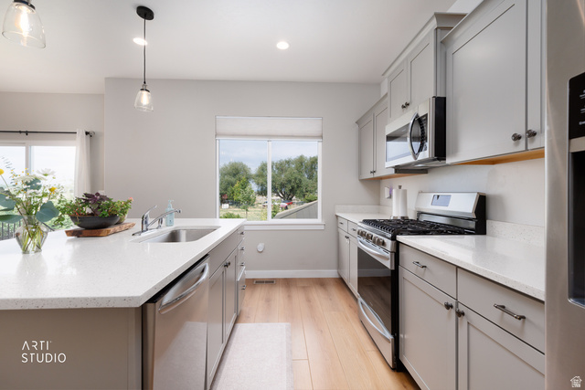 1654 South 730 West Provo, UT 84601 - Photo 11 of 33 Modern kitchen featuring light gray cabinetry, stainless steel appliances, a center island with an undermount sink, and recessed lighting