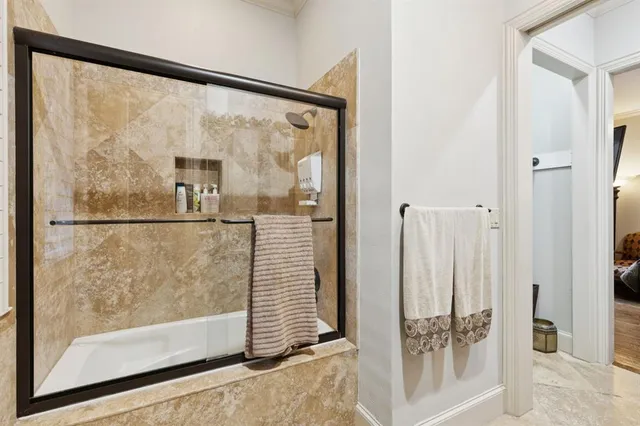 a bathroom with a glass shower door and a window
