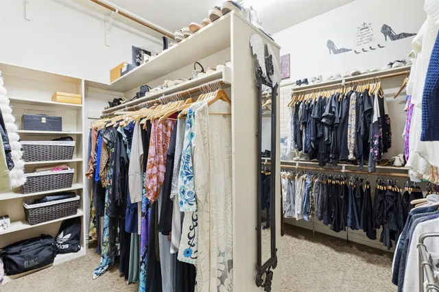 a view of walk in closet with clothes and shoes