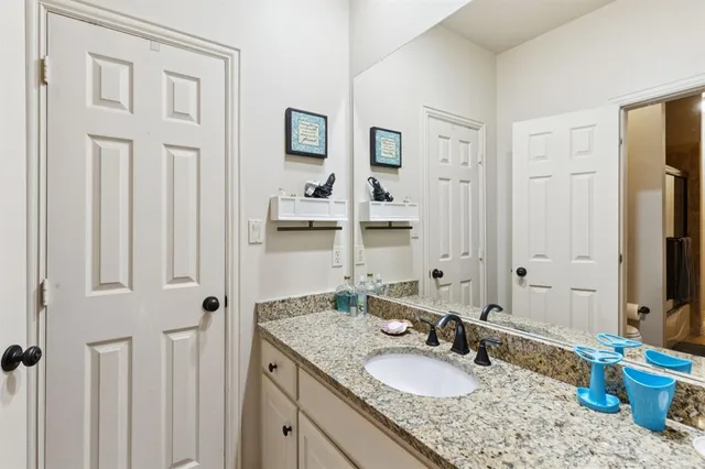 a bathroom with a granite countertop sink and a mirror