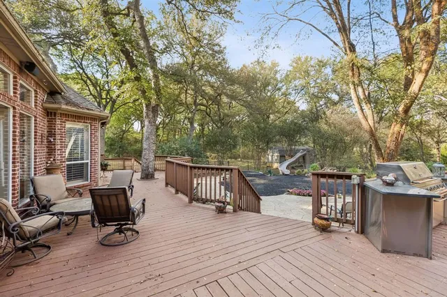 a view of a patio with dining table and chairs with wooden floor and fence